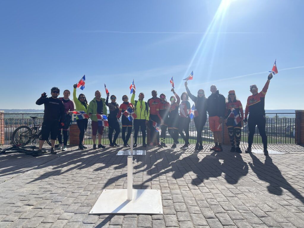 Grupo de MTBSPAIN celebrando con banderas en una etapa del Camino de Santiago, experiencia de equipo para empresas