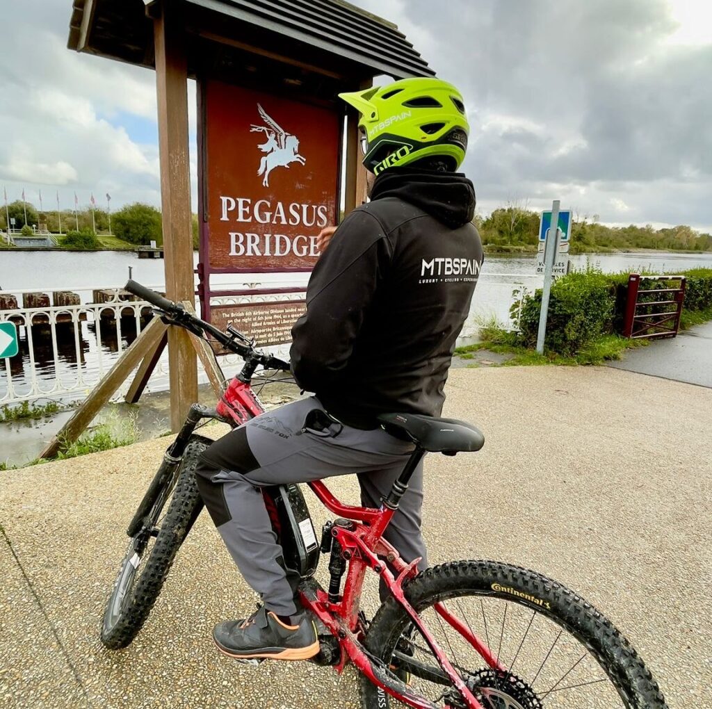 Ciclista de MTBSPAIN con su bicicleta en Pegasus Bridge, Normandía