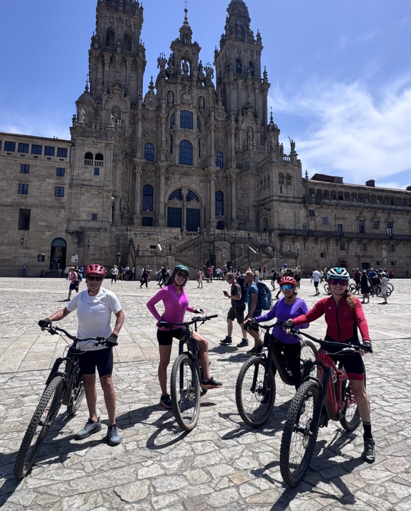 Grupo de ciclistas con bicicletas eléctricas llegando a la plaza del Obradoiro de Santiago de Compostela