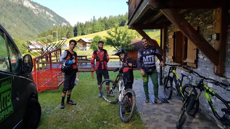 Grupo de MTBSPAIN con sus bicicletas frente a un chalet alpino en Portes du Soleil
