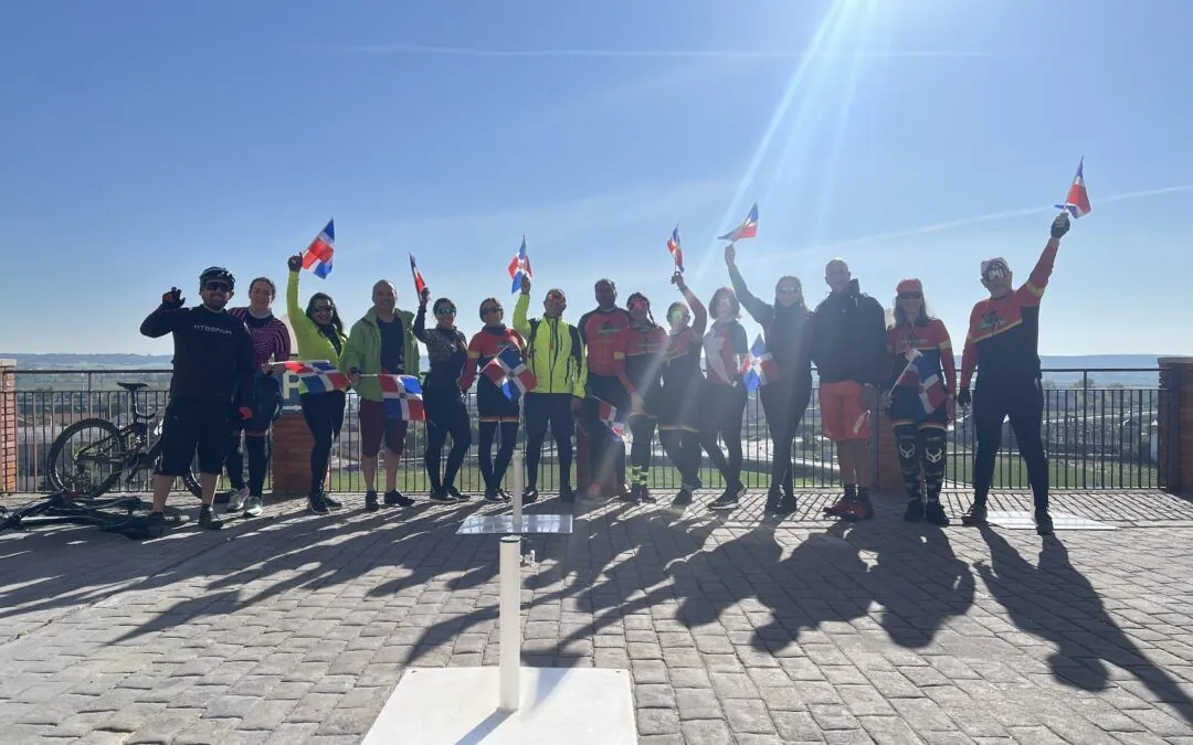 Grupo de ciclistas de MTBSPAIN celebrando con banderas en una etapa del Camino de Santiago desde León