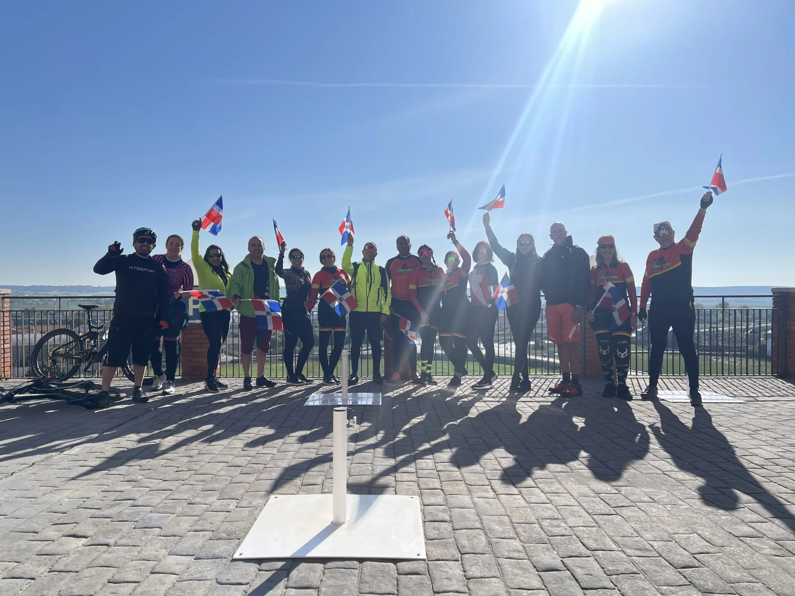 Grupo de ciclistas de MTBSPAIN celebrando con banderas en una etapa del Camino de Santiago desde León